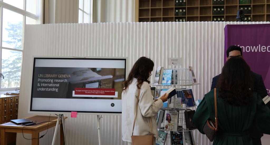 This photo shows guests at a Commons event who are browsing books on multilateralism available at the Library & Archives.