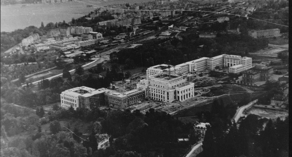 This image is a black and white photos from the UN Archives Geneva. It shows an aerial view of the Palais des Nations during the time of the League of Nations.