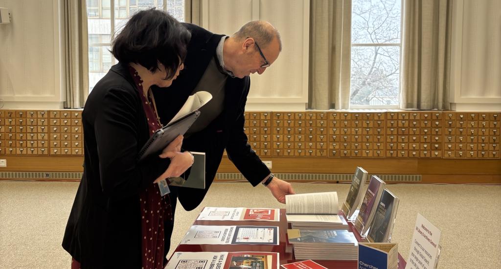 A participant at the META-UN Launch Conference browses resources with a librarian from the UN Library & Archives Geneva.