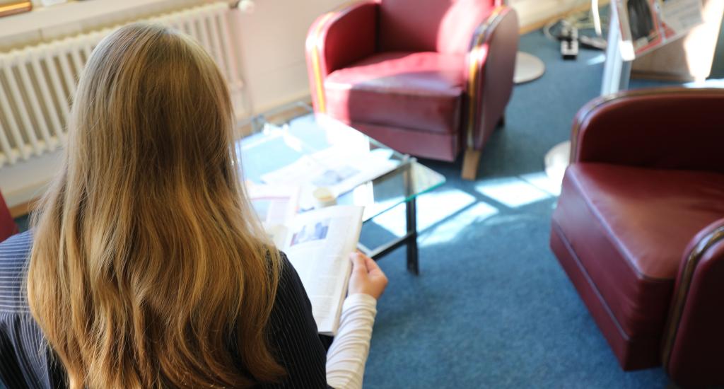 A Library user reads a journal in the Library Lounge.