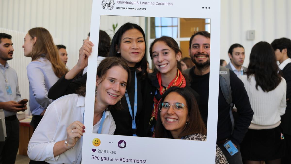 This is a photo from the event. It shows four young women who attended the event, posing with the Commons Instagram frame. Other guests are featured in the background. 