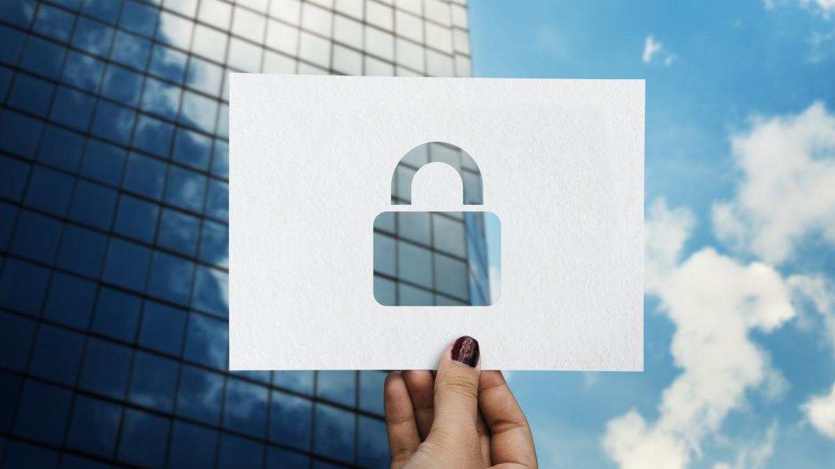 Picture of a building in the background with a perforated paper padlock