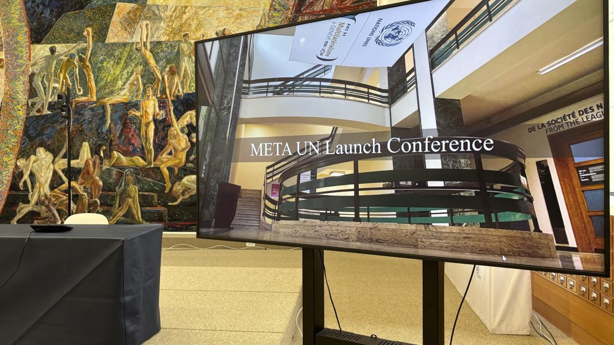 This photo shows a TV screen with the name if the conference: META-UN Launch Conference. The backdrop is the Library Events Room at the UN Library & Archives Geneva.