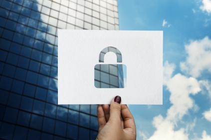 Picture of a building in the background with a perforated paper padlock